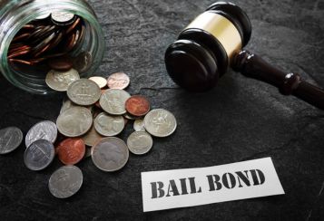 Gavel and coins with a bail bond sign for cheap bail bonds in Liberty