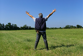 Man celebrating freedom in a field after bail bonds in Dallas