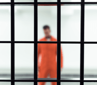 Inmate behind jail bars waiting for 24 hour bail bonds in San Antonio