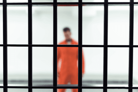 Inmate behind jail bars waiting for local bail bonds in Sharpstown