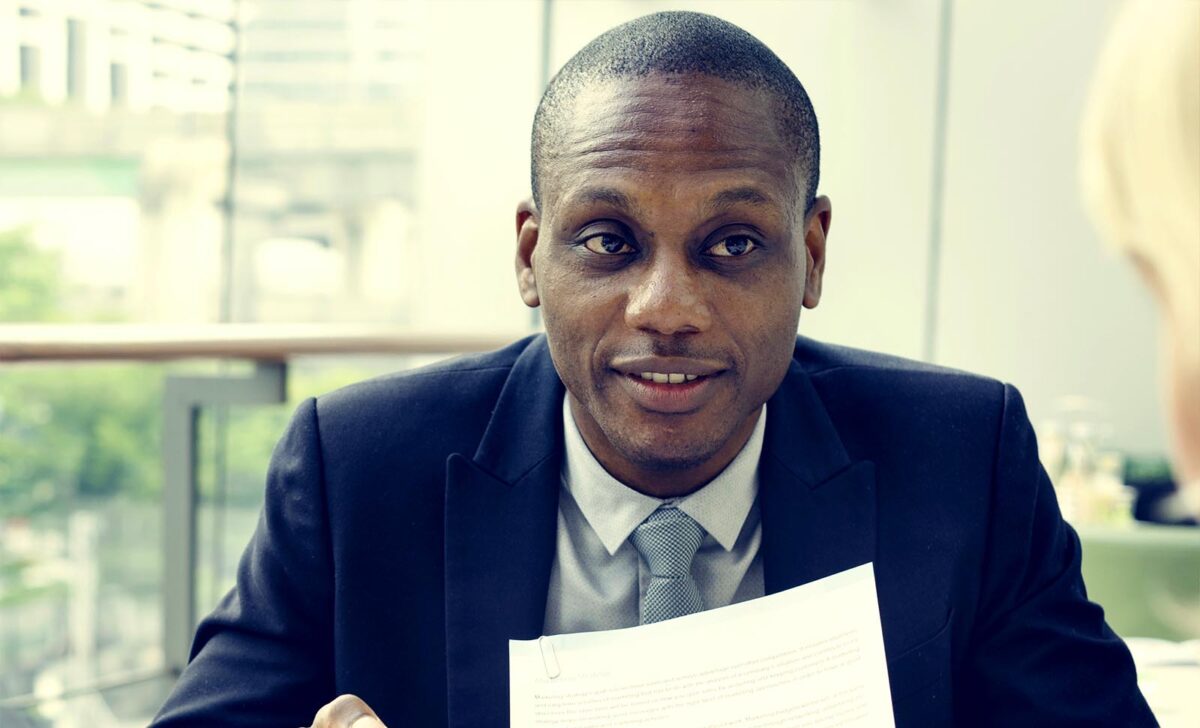 Smiling bail bondsman holding bail bond paperwork in Houston